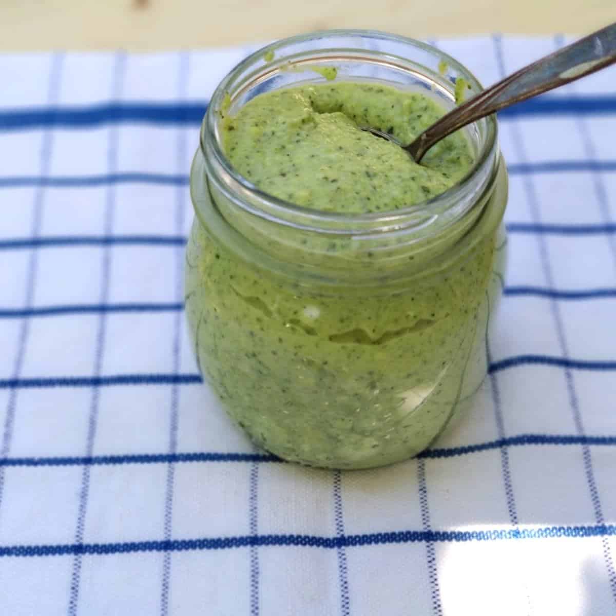 zucchini Pesto in a jar with a spoon inside