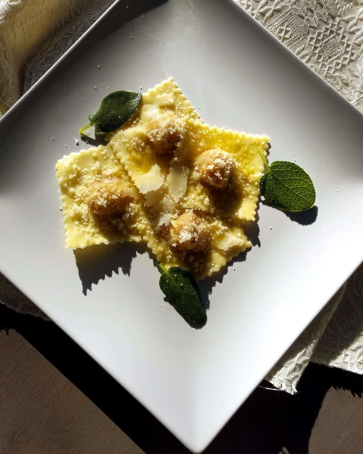 Pumpkin Ravioli  from above showing  grated parmesan and sage leaves on top