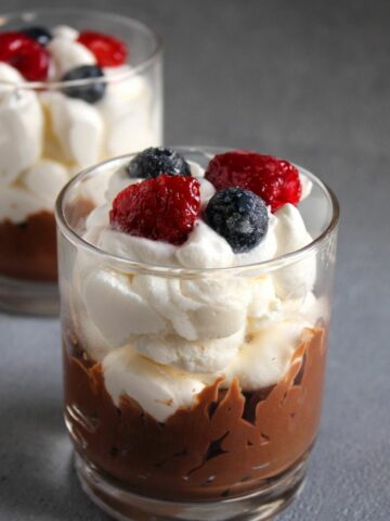 Two Chocolate Trifles in a glass. They are topped with wild berries