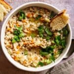 a-bowl-of-farro-and-cabbage-soup-with-a-slice-of-bread