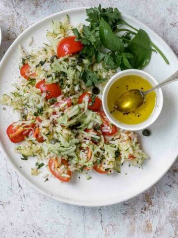 Zucchini rice salad in a plate with sauce and capers