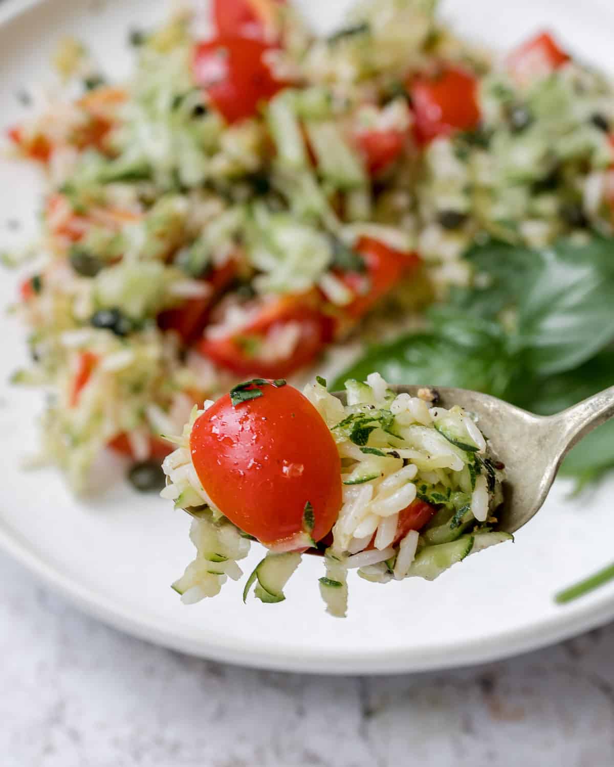 a bite of zucchini rice salad with cherry tomato