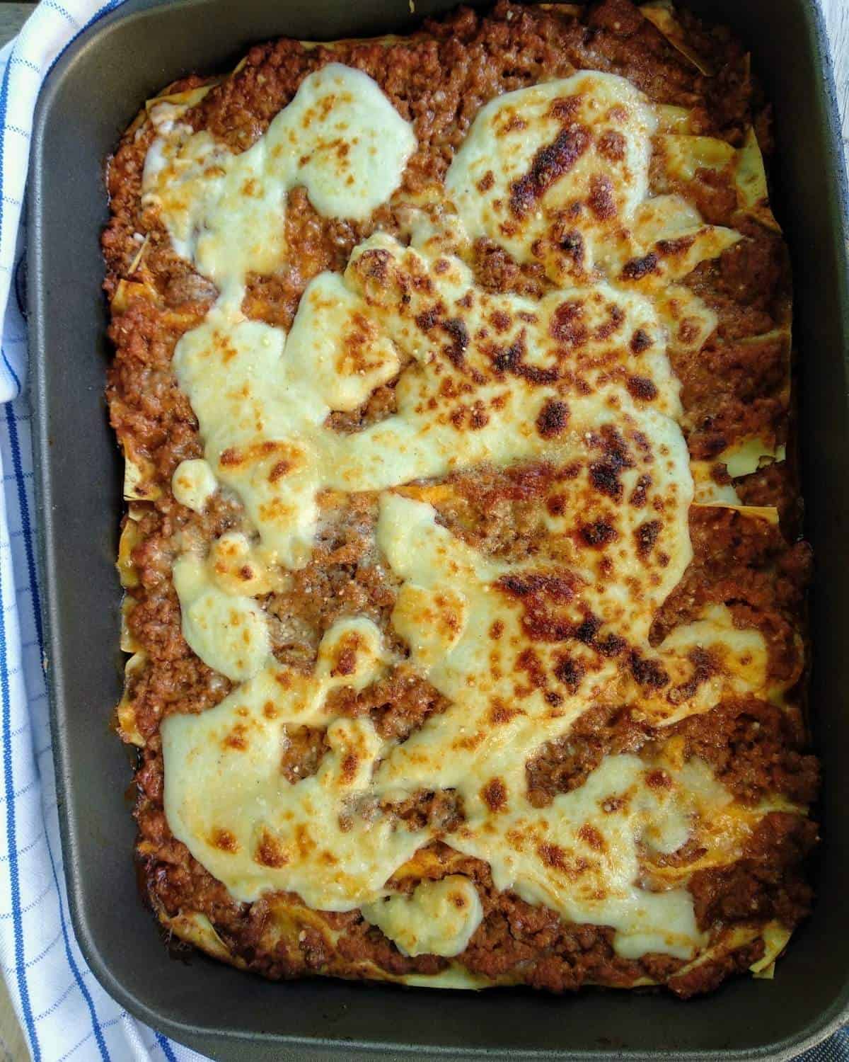 A view from above Bolognese Lasagne in a grey baking tray. 