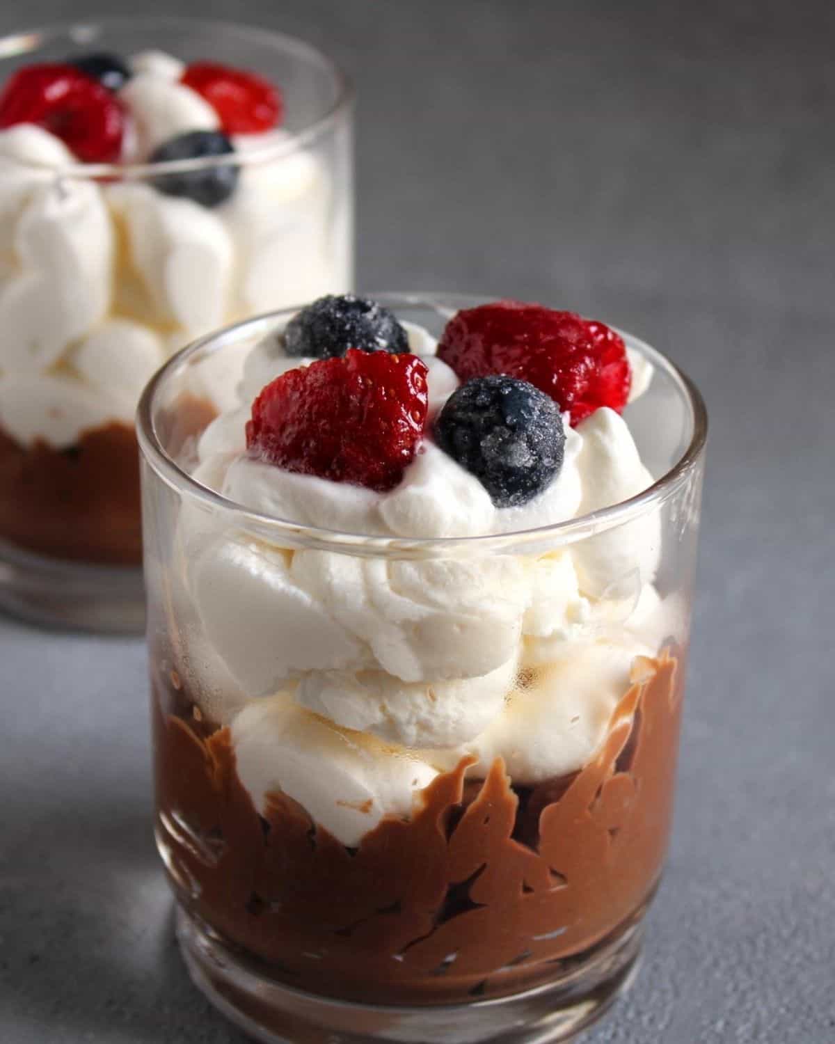Two Chocolate Trifles in a glass. They are topped with wild berries 