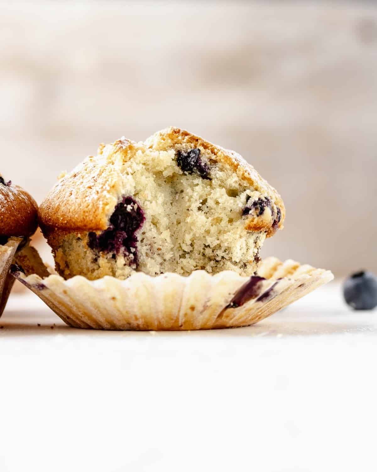 Close-up of an open blueberry muffins over a table. Inside the muffin you can see the cooked blueberries