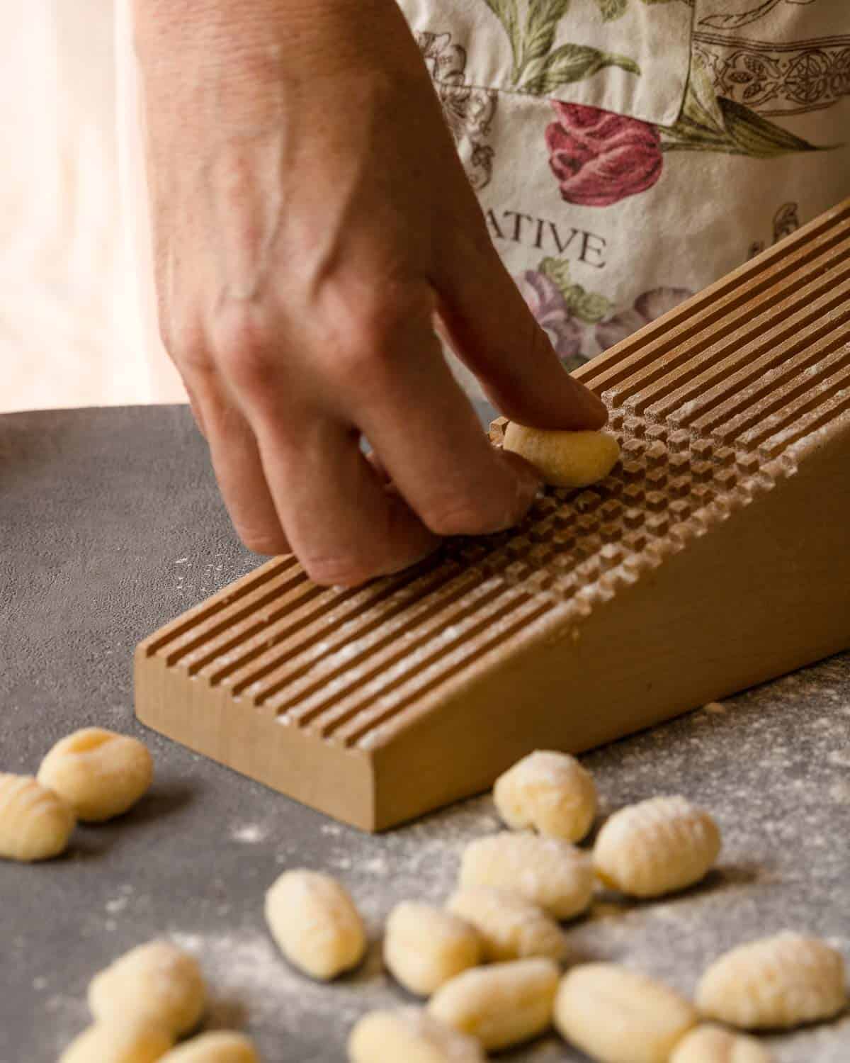 rolling each ‘gnocco’ down the back of a fork or a grater to avoid the gnocchi to absorb maximum flavor