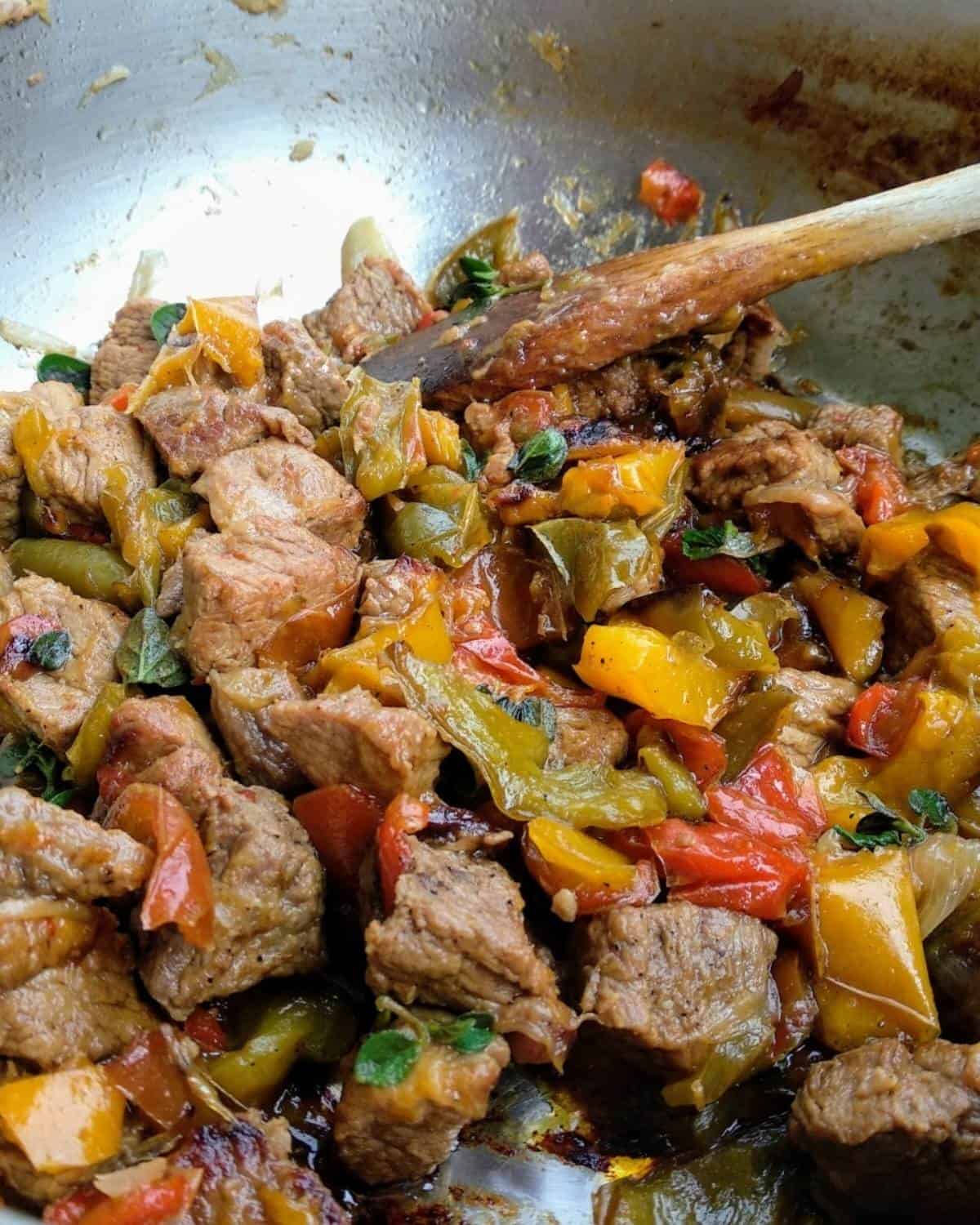 Tossing the Peppers Beef Stew with a wooden spoon.