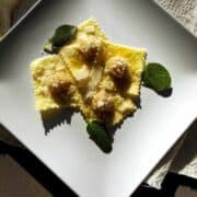 Pumpkin Ravioli from above showing grated parmesan and sage leaves on top