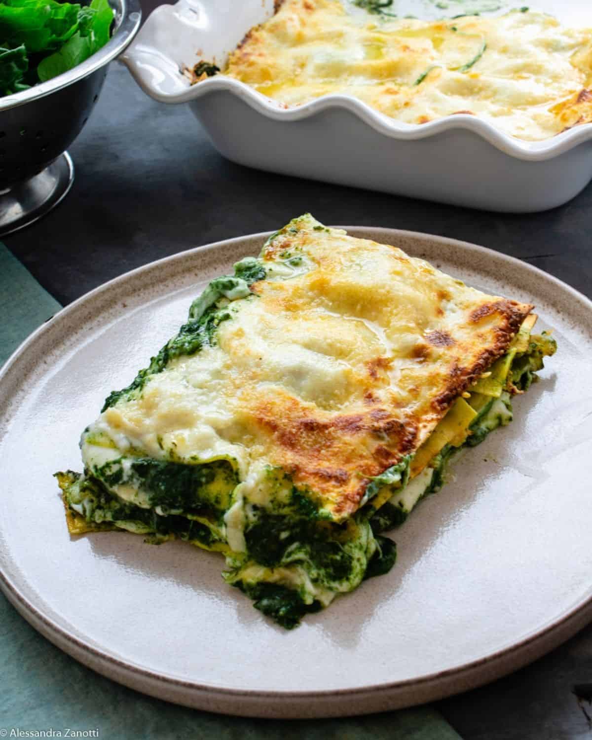 A slice Spinach Lasagna showing all the layers with Mozzarella and Spinach