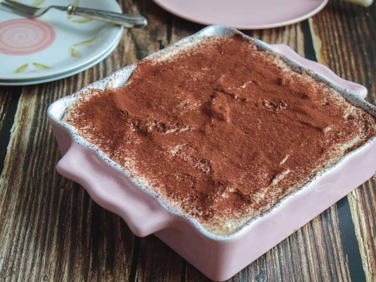 Closed up of Tiramisu Cake on a pink pan on a wooden table
