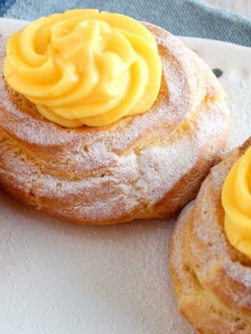 A close up from above of Italian Zeppole. They show the plenty filling of custard