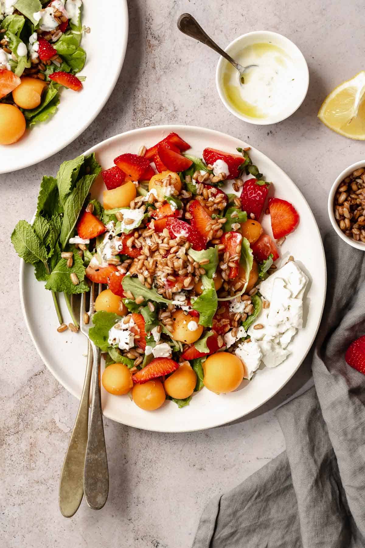 plate with farro salad, little plate with melon, bowl with yogurt and bowl with farro